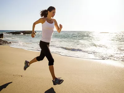 Mixed race woman running on beach