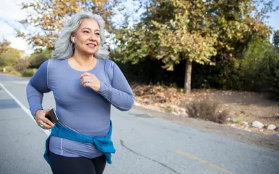 Mature Mexican woman jogging on a traile