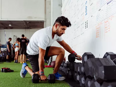 man using dumbbells at a gym