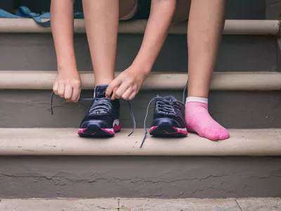 Young Woman Putting On Exercise Shoes