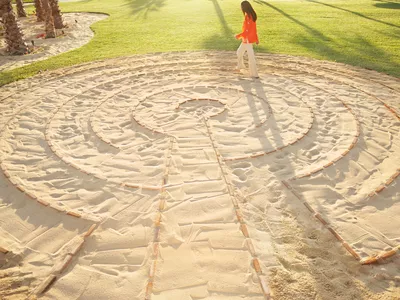 Woman walking in a meditation labyrinth at a luxury resort and spa in Los Cabos, Mexico.