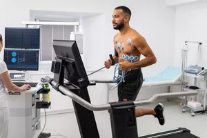 Athlete does a cardiac stress test in a medical study, monitored by the female doctor.