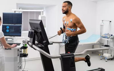 Athlete does a cardiac stress test in a medical study, monitored by the female doctor.