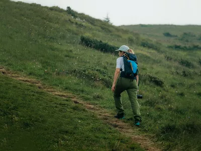 Caucasian Female Hiker in beautiful mountain scenery during the daytime.