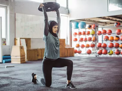 Young woman on cross training exercising. Wearing sports clothing and hijab.