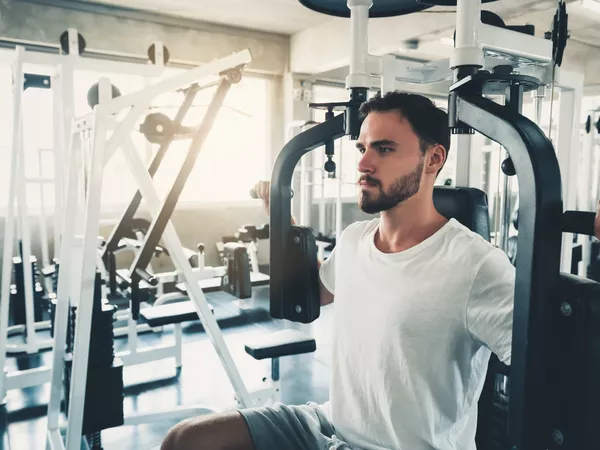 Handsome Man is Exercising With Pectoral Machine in Fitness Club.,Portrait of Strong Man Doing Working Out Calories Burning in Gym., Healthy and Fitness Lifestyle Concept.