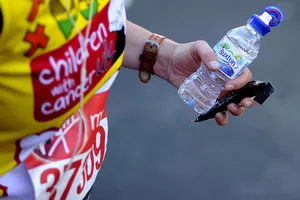 A runner holds an energy bar and a bottle of water during the Virgin Money London Marathon on April 13, 2014 in London, England.