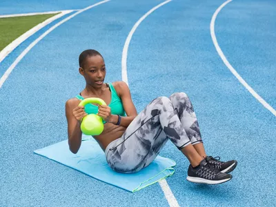Woman working out with a kettle bell, training outdoors