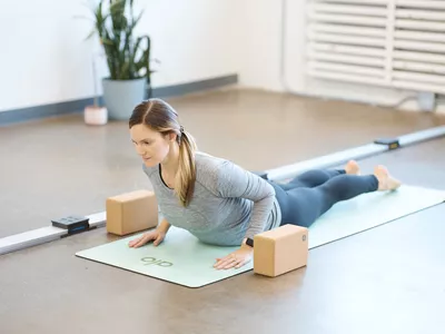 A person practicing yoga on Alo Yoga Warrior Mat