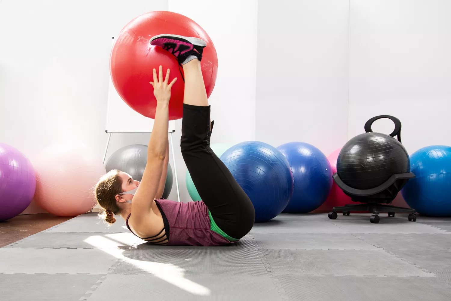 Person exercising using GoFit Pro Grade Stability Ball on gym mats