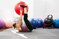 Person exercising using GoFit Pro Grade Stability Ball on gym mats