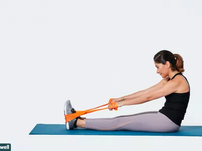 woman doing seated upper back stretch with resistance band