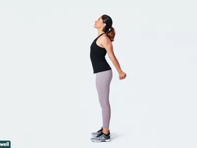 woman doing standing chest stretch
