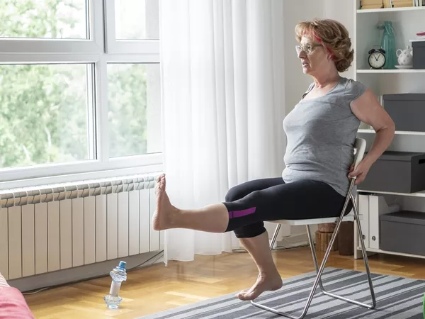 Woman performing ab exercises in a chair in living room