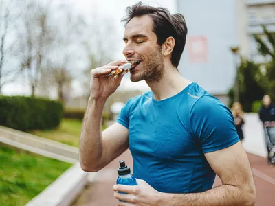 Male athlete eating protein bar