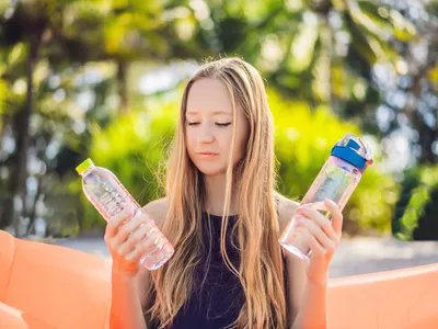woman debating between water and electrolytes
