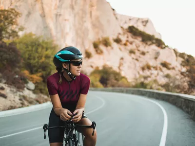 Portrait of Cyclist Woman on Road Bike with Sunglasses and Helmet