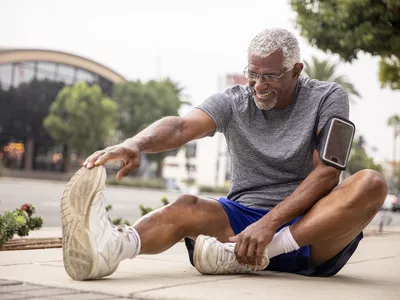 man sitting and stretching hamstrings
