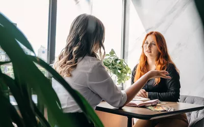 Two women talking at a desk