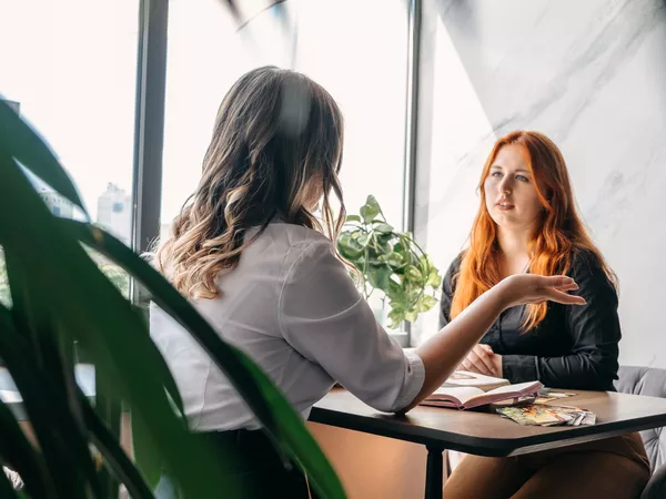 Two women talking at a desk