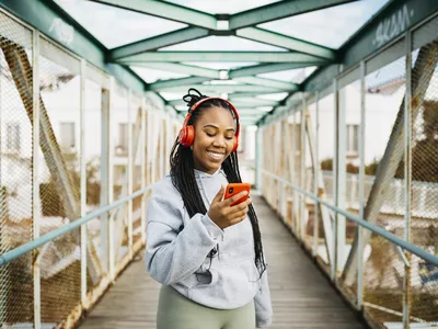 woman wearing headphones while exercising with phone