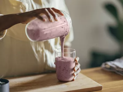 Anonymous Afro-American Woman Pouring a Smoothie into a Glass