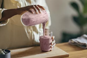 Anonymous Afro-American Woman Pouring a Smoothie into a Glass