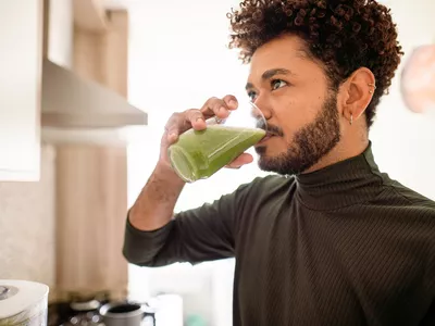 Man drinking a green smoothie