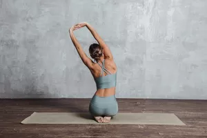 Woman stretching back with arms overhead on an exercise mat