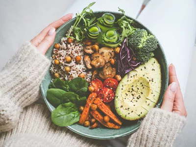 Healthy eating and healthy diet. Woman holding plate with fresh vegan or vegetarian food. Healthy vegan meal. Vegan buddha bowl with healthy food