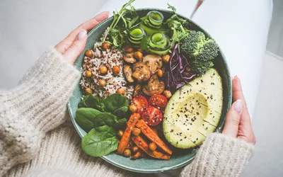 Healthy eating and healthy diet. Woman holding plate with fresh vegan or vegetarian food. Healthy vegan meal. Vegan buddha bowl with healthy food