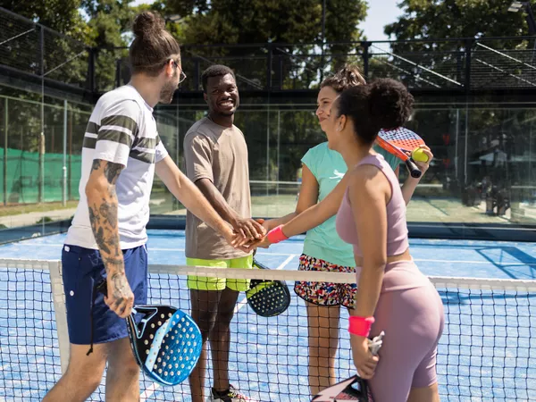 Four friends shaking hands before playing pickleball