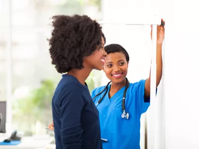 Nurse measuring woman's height