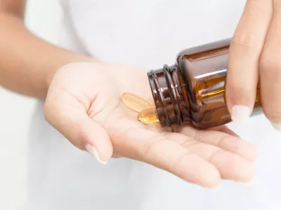 closeup hand holding fish oil vitamin for healthy