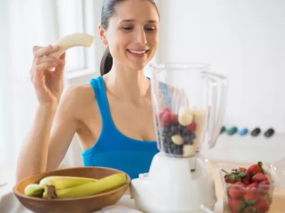 Caucasian woman blending fruit smoothie