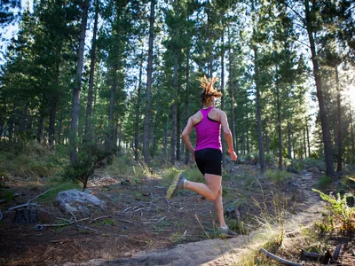 Female runner going for an early morning run in the forest.