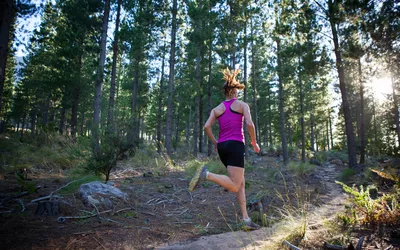 Female runner going for an early morning run in the forest.