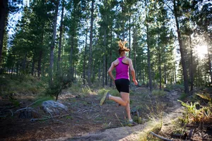 Female runner going for an early morning run in the forest.