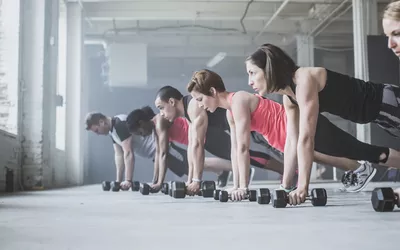 Group Doing Pushups with Dumbbells