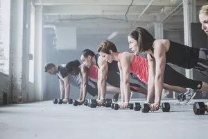 Group Doing Pushups with Dumbbells