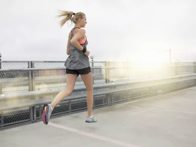 Young woman running, outdoors, rear view