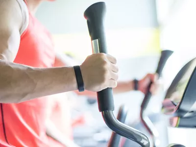 close up of man on elliptical trainer exercise machine