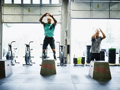 men doing box jumps in crossfit gym