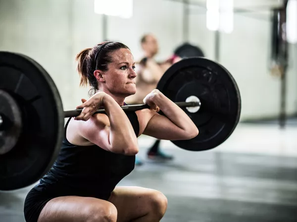 Woman lifting barbell at a gym