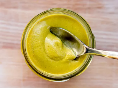 jar of dijon mustard with a spoon in it