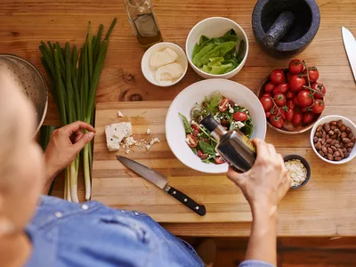 Pouring balsamic vinegar over a salad