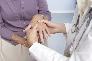 General practitioner examining a patient's hand