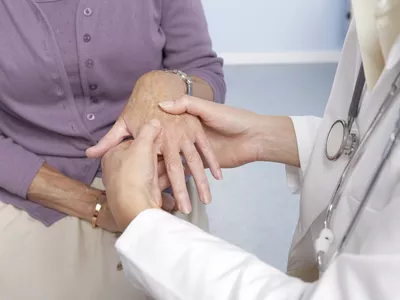 General practitioner examining a patient's hand