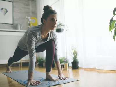 Young woman practicing iyengar yoga at home in her living room