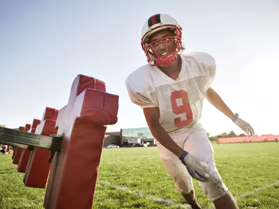 American football player training on sled at field 